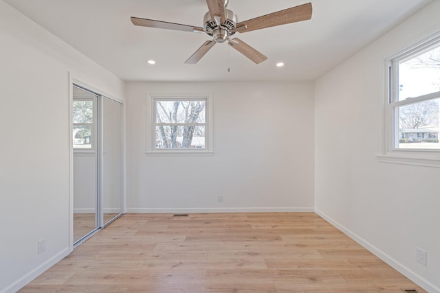 unfurnished bedroom featuring light hardwood / wood-style flooring, a closet, and ceiling fan