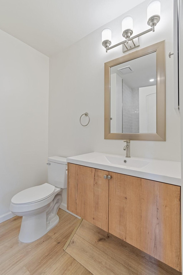 bathroom with vanity, hardwood / wood-style floors, and toilet