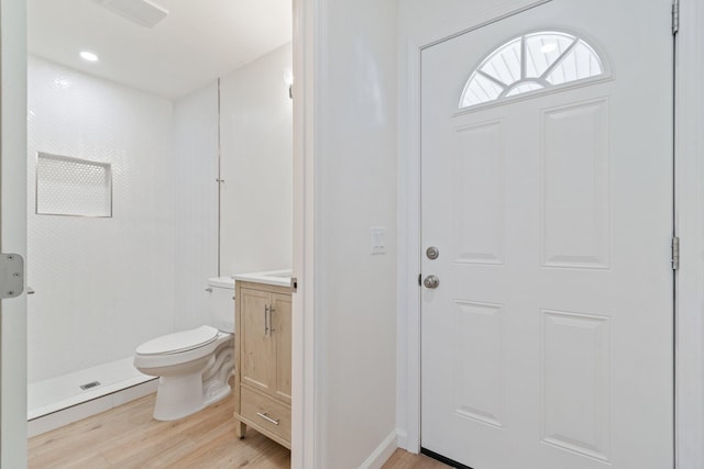 bathroom featuring vanity, toilet, hardwood / wood-style floors, and a shower