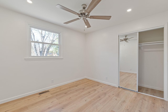 unfurnished bedroom featuring light hardwood / wood-style floors, a closet, and ceiling fan