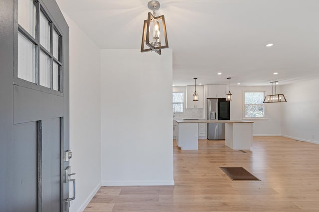 entrance foyer with a chandelier and light wood-type flooring