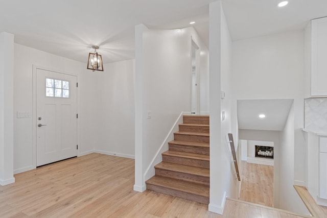 foyer entrance with a notable chandelier and light hardwood / wood-style flooring