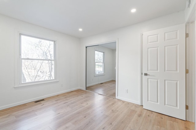 unfurnished bedroom featuring light hardwood / wood-style flooring and a closet