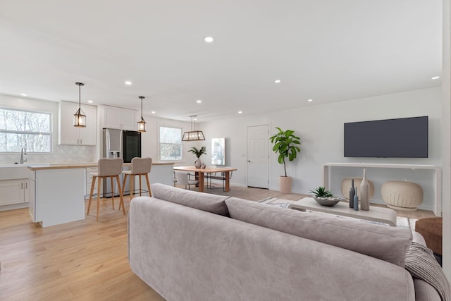 living room featuring sink, a wealth of natural light, and light hardwood / wood-style flooring