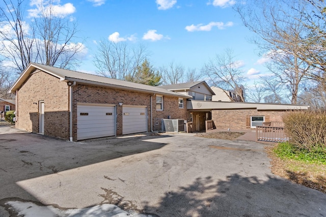 view of front of property featuring a garage and central AC unit