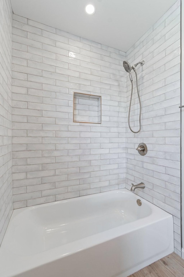 bathroom with tiled shower / bath and wood-type flooring