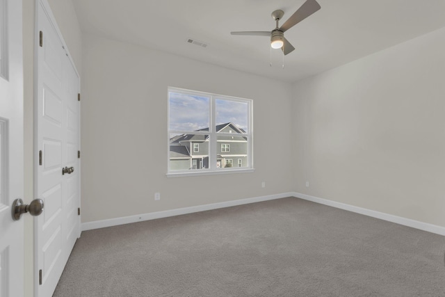 carpeted spare room featuring ceiling fan