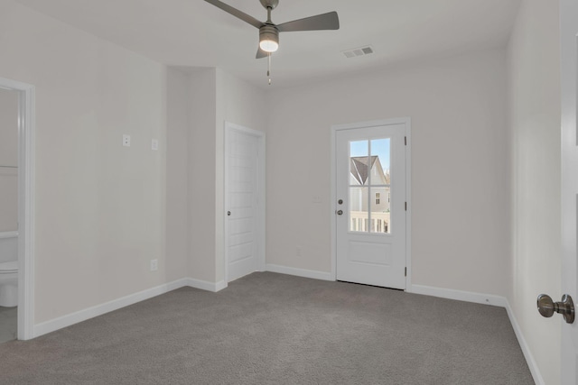 carpeted spare room with ceiling fan