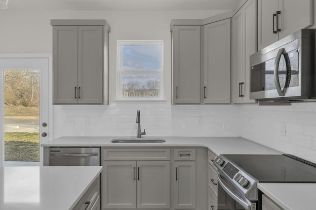 kitchen featuring sink, a wealth of natural light, gray cabinets, and appliances with stainless steel finishes