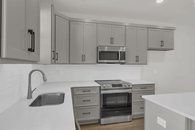 kitchen with gray cabinets, tasteful backsplash, appliances with stainless steel finishes, and sink