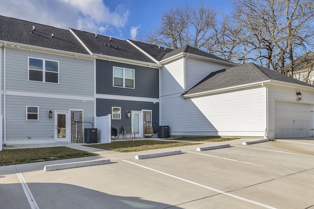 exterior space with a garage and central AC unit