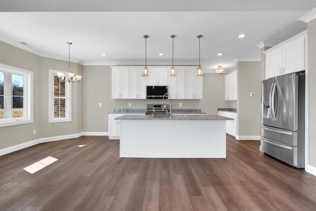 kitchen with crown molding, appliances with stainless steel finishes, a kitchen island with sink, hanging light fixtures, and white cabinets