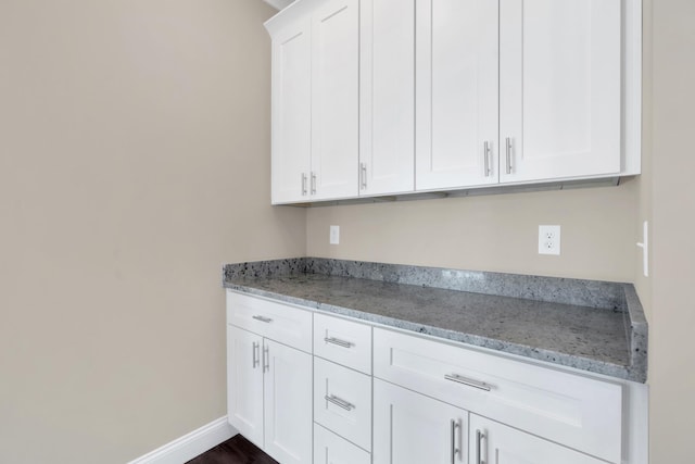 kitchen with light stone countertops and white cabinets