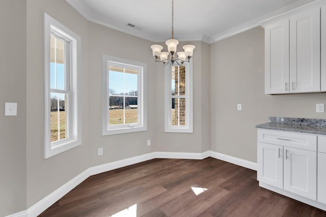 unfurnished dining area featuring ornamental molding, an inviting chandelier, and dark hardwood / wood-style flooring