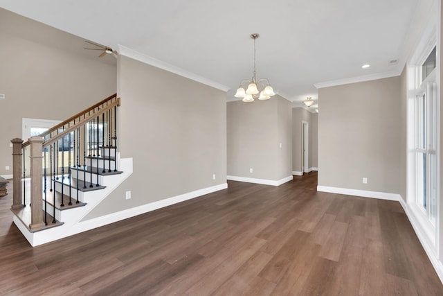 unfurnished living room with dark hardwood / wood-style flooring, crown molding, plenty of natural light, and ceiling fan with notable chandelier