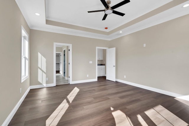 interior space featuring a tray ceiling, dark wood-type flooring, ornamental molding, and ceiling fan