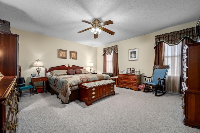 bedroom featuring multiple windows, ceiling fan, light colored carpet, and a textured ceiling