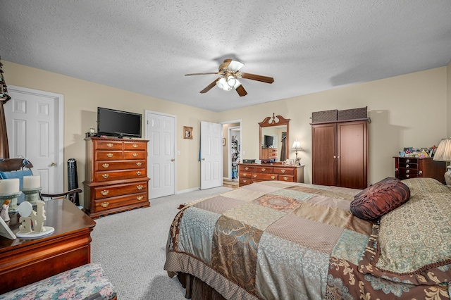 carpeted bedroom featuring a textured ceiling and ceiling fan