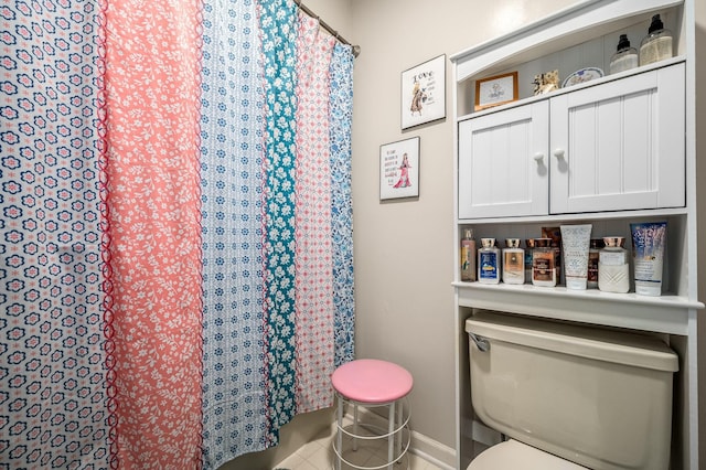 bathroom with tile patterned floors, toilet, and walk in shower