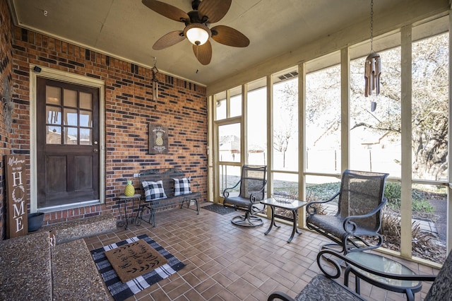 unfurnished sunroom with ceiling fan