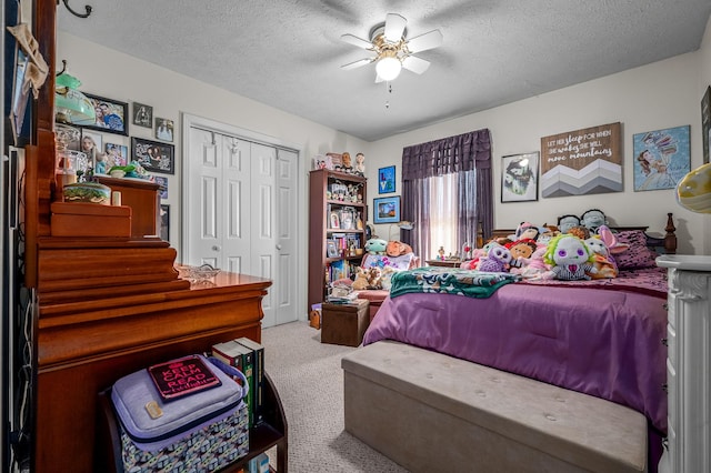 carpeted bedroom with a textured ceiling, a closet, and ceiling fan