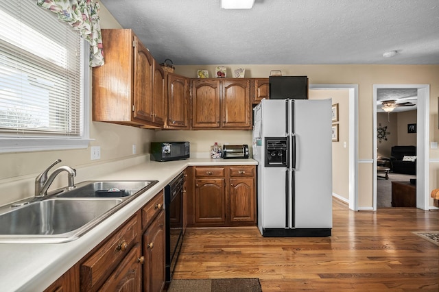 kitchen featuring dark hardwood / wood-style floors, sink, a textured ceiling, and black appliances