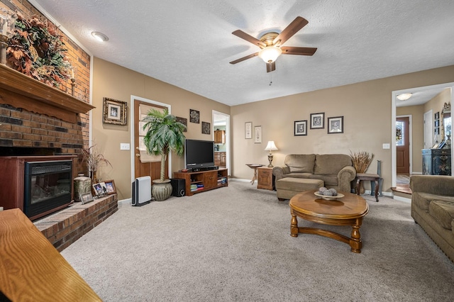 carpeted living room with ceiling fan, a brick fireplace, and a textured ceiling