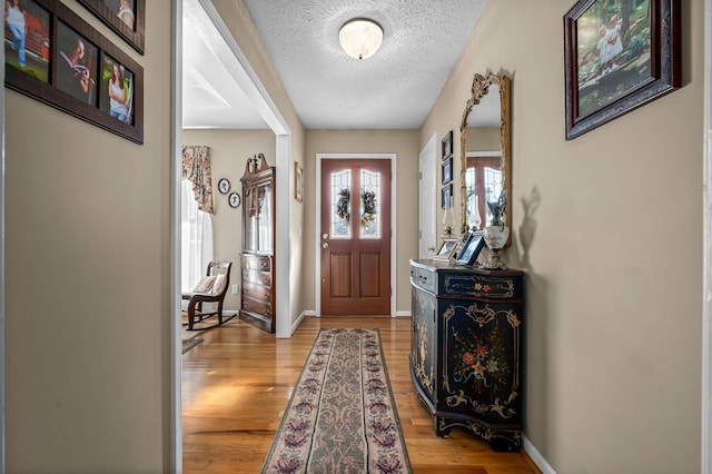 entryway featuring a textured ceiling and light hardwood / wood-style floors