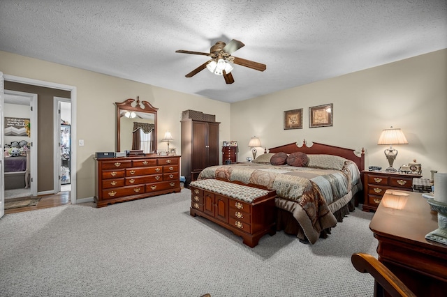 carpeted bedroom featuring a textured ceiling and ceiling fan