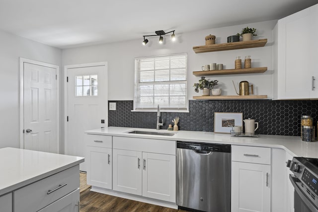 kitchen featuring sink, appliances with stainless steel finishes, dark hardwood / wood-style flooring, decorative backsplash, and white cabinets