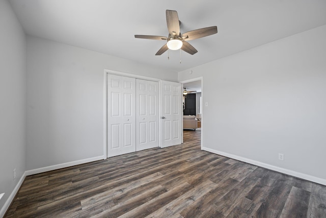 unfurnished bedroom with dark wood-type flooring, a closet, and ceiling fan