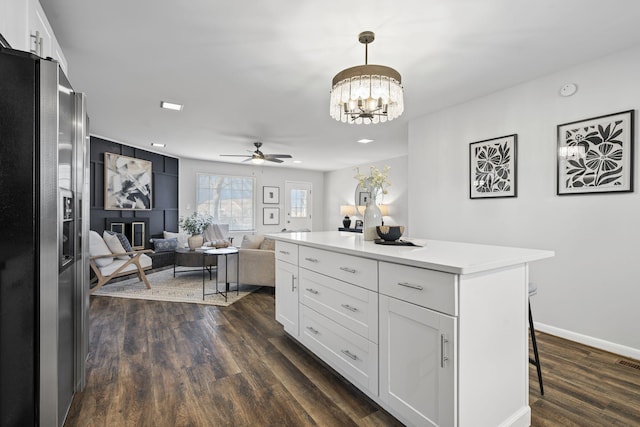 kitchen with stainless steel refrigerator with ice dispenser, white cabinetry, decorative light fixtures, and a kitchen island