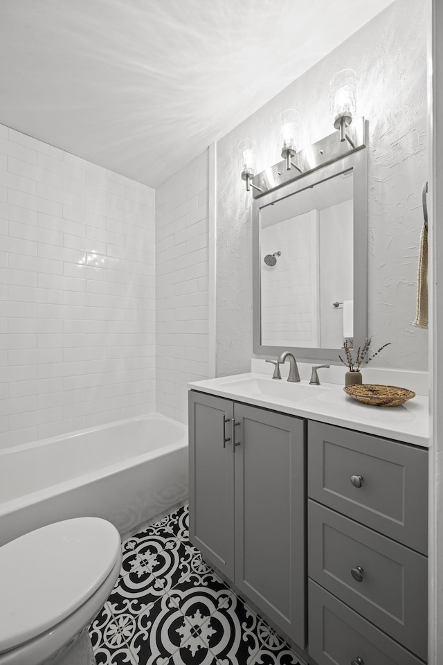 full bathroom featuring vanity, toilet, tiled shower / bath combo, and tile patterned flooring