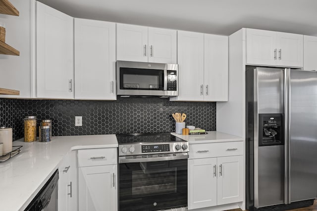 kitchen featuring stainless steel appliances, white cabinetry, light stone countertops, and tasteful backsplash