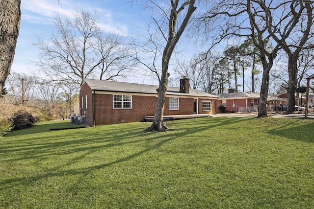 rear view of property with a yard and central AC