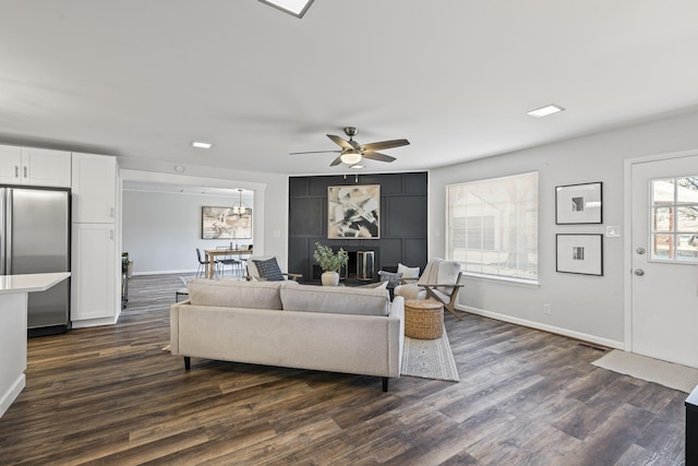 living room featuring dark wood-type flooring and ceiling fan