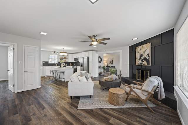 living room with ceiling fan and dark hardwood / wood-style flooring