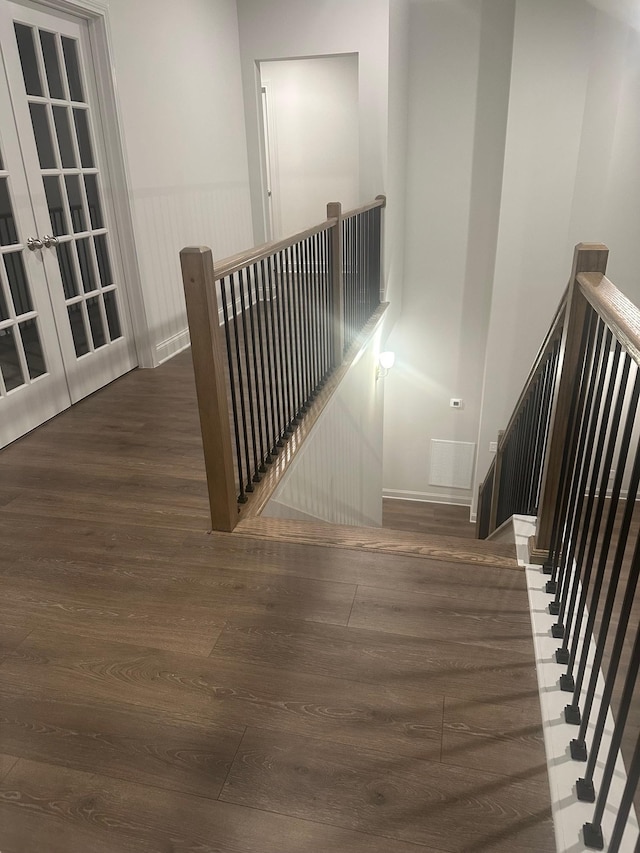 stairway featuring hardwood / wood-style flooring and french doors