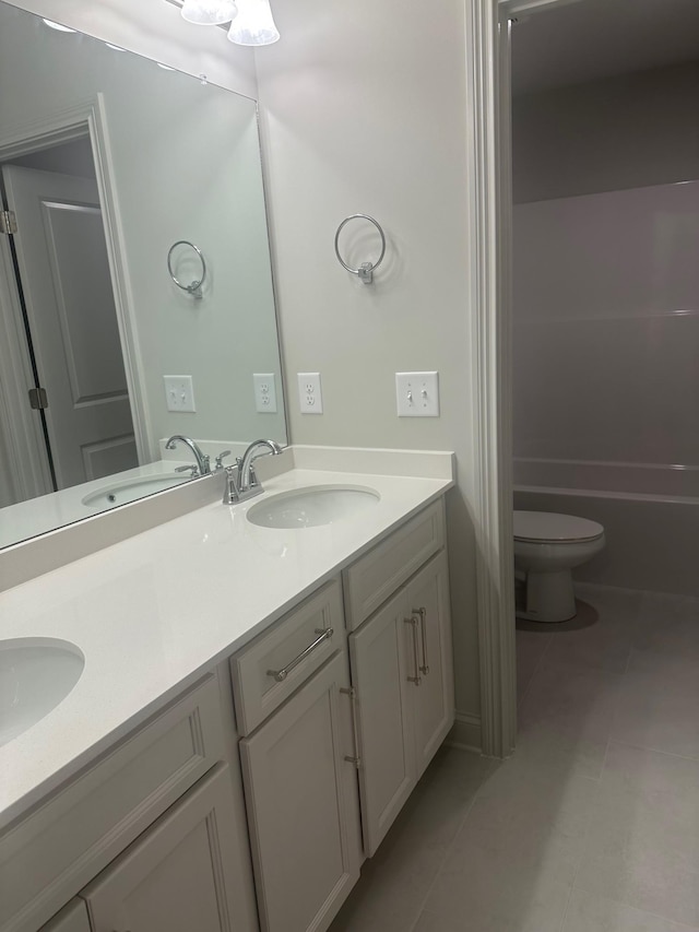 bathroom with tile patterned flooring, vanity, and toilet