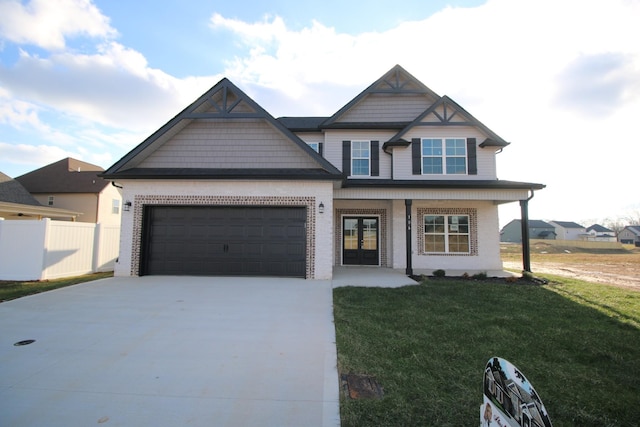 view of front of property with a porch, a garage, and a front yard