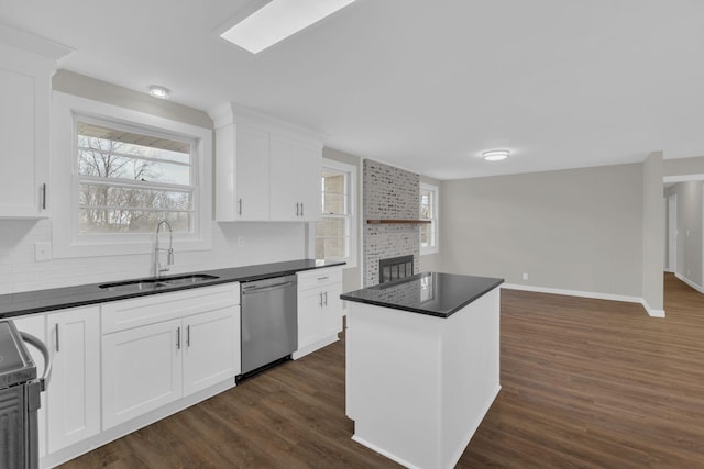 kitchen with a sink, dark countertops, stove, and stainless steel dishwasher