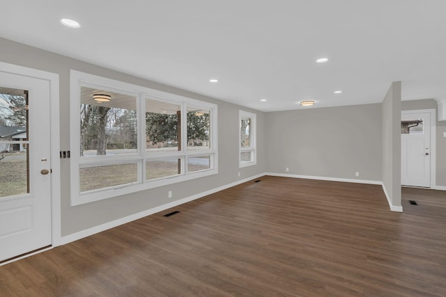 unfurnished living room featuring dark wood finished floors, visible vents, and recessed lighting