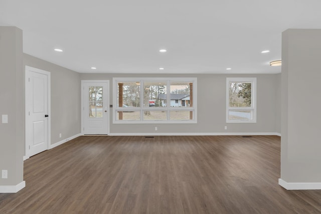 unfurnished living room with recessed lighting, dark wood-style flooring, and baseboards