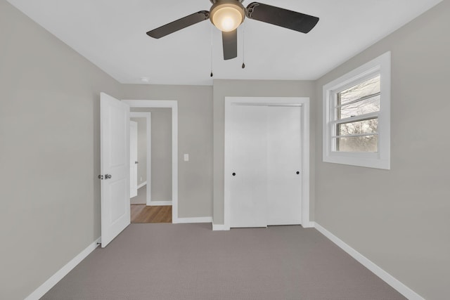 unfurnished bedroom featuring carpet floors, ceiling fan, baseboards, and a closet