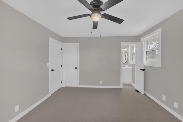 unfurnished bedroom with a ceiling fan, carpet, baseboards, and ensuite bathroom