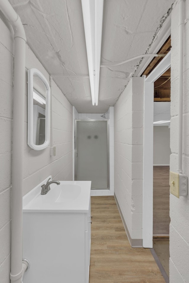 bathroom featuring a shower, vanity, and wood finished floors