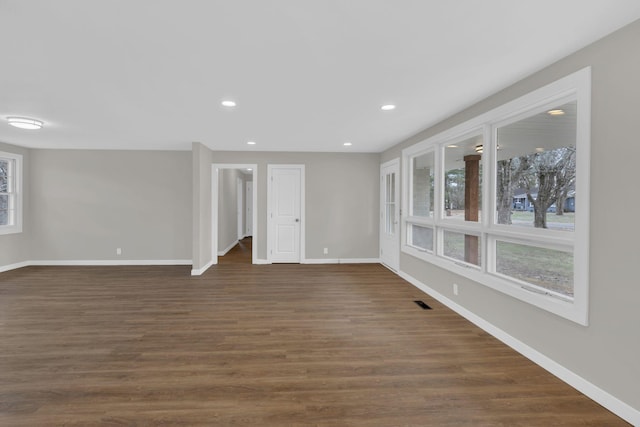 empty room featuring baseboards, dark wood finished floors, and recessed lighting