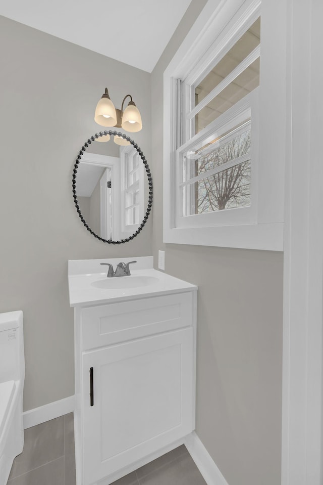 bathroom with toilet, tile patterned floors, vanity, and baseboards