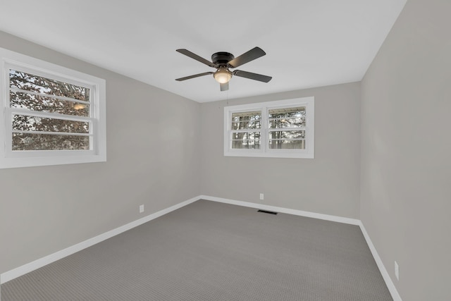 carpeted spare room featuring visible vents, ceiling fan, and baseboards