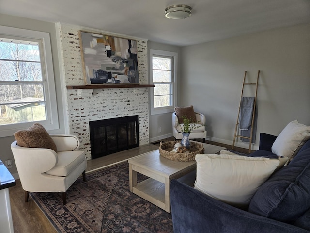 living room featuring a fireplace, wood finished floors, and baseboards